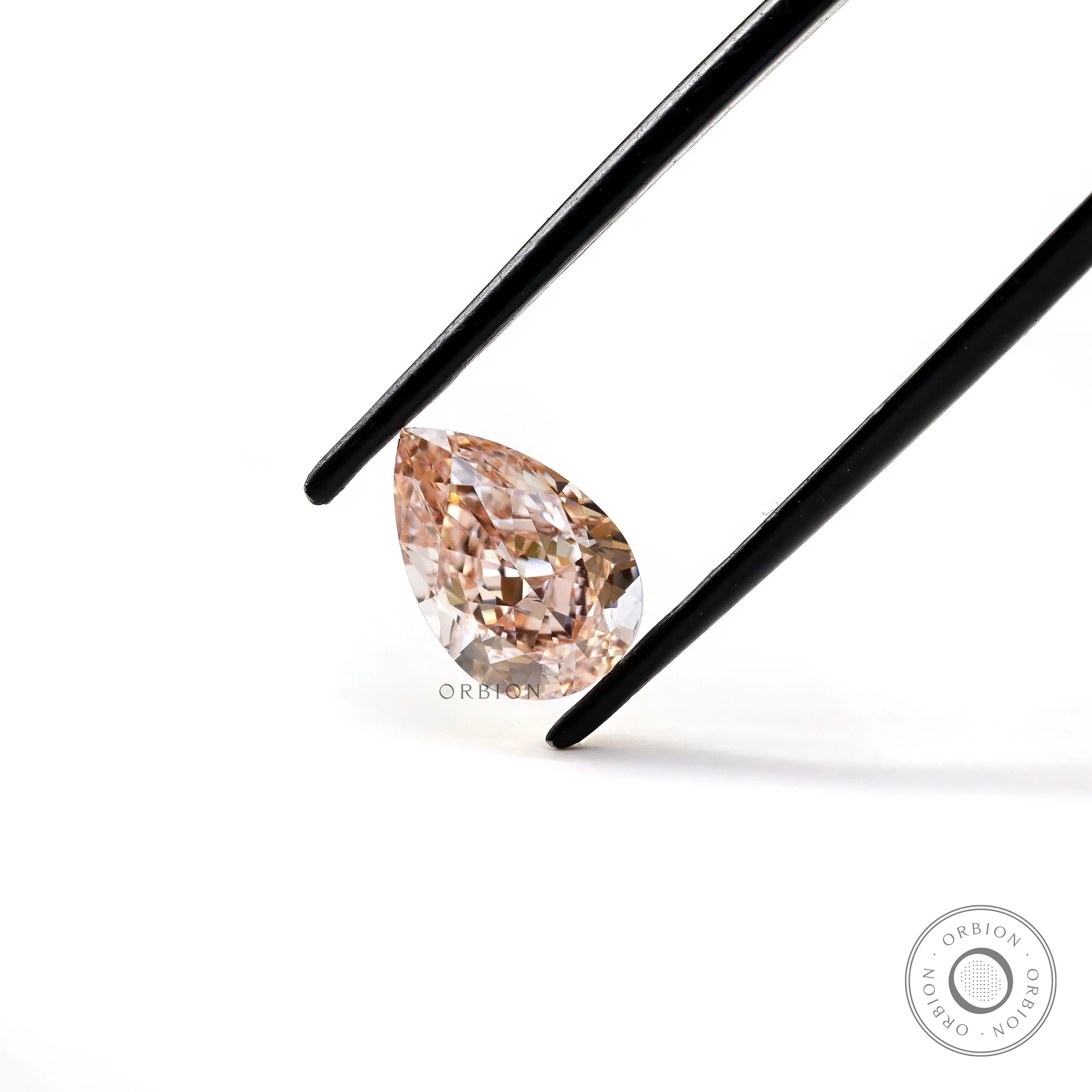Angled tweezers view of pear pink loose diamond