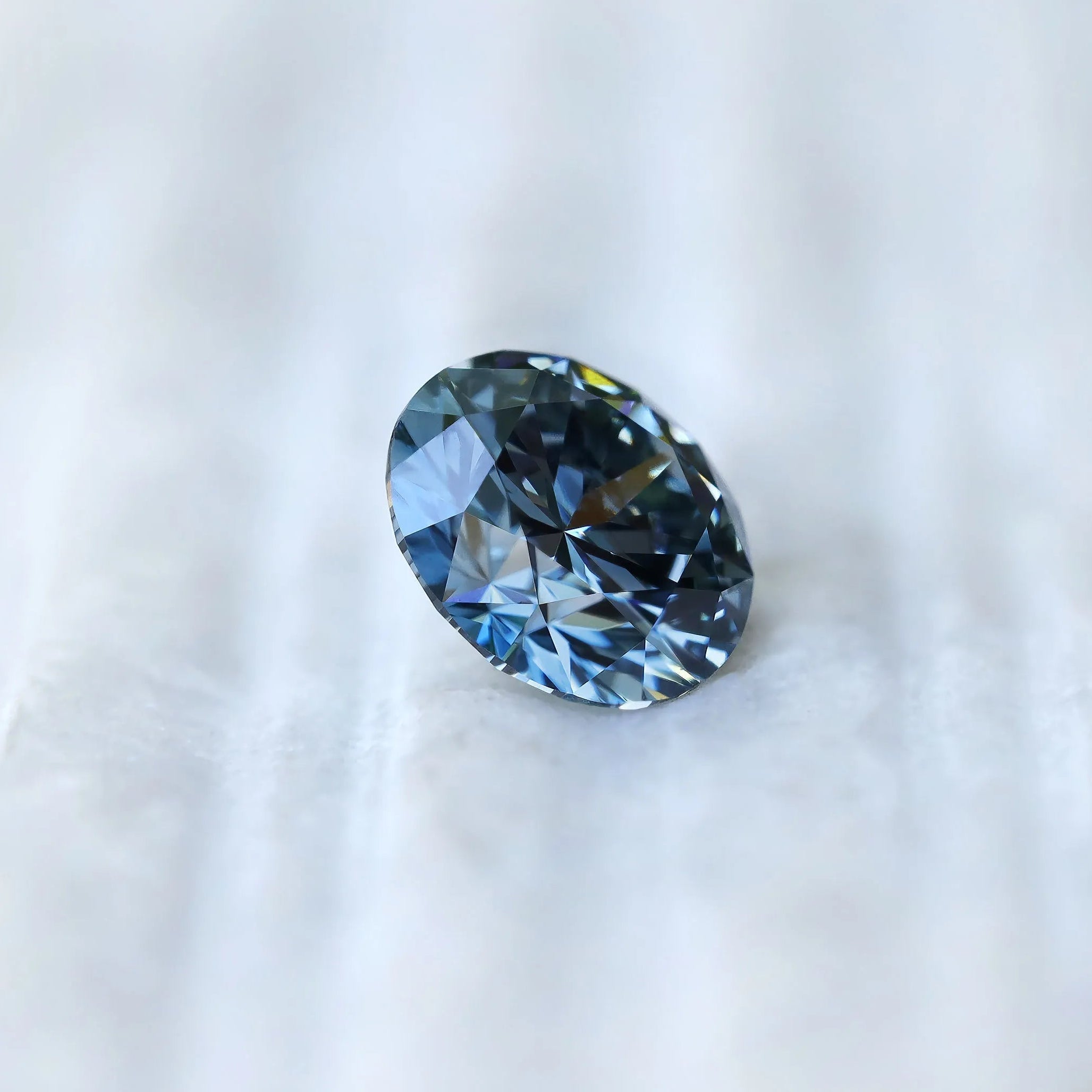 Profile side view of round intense blue loose diamond