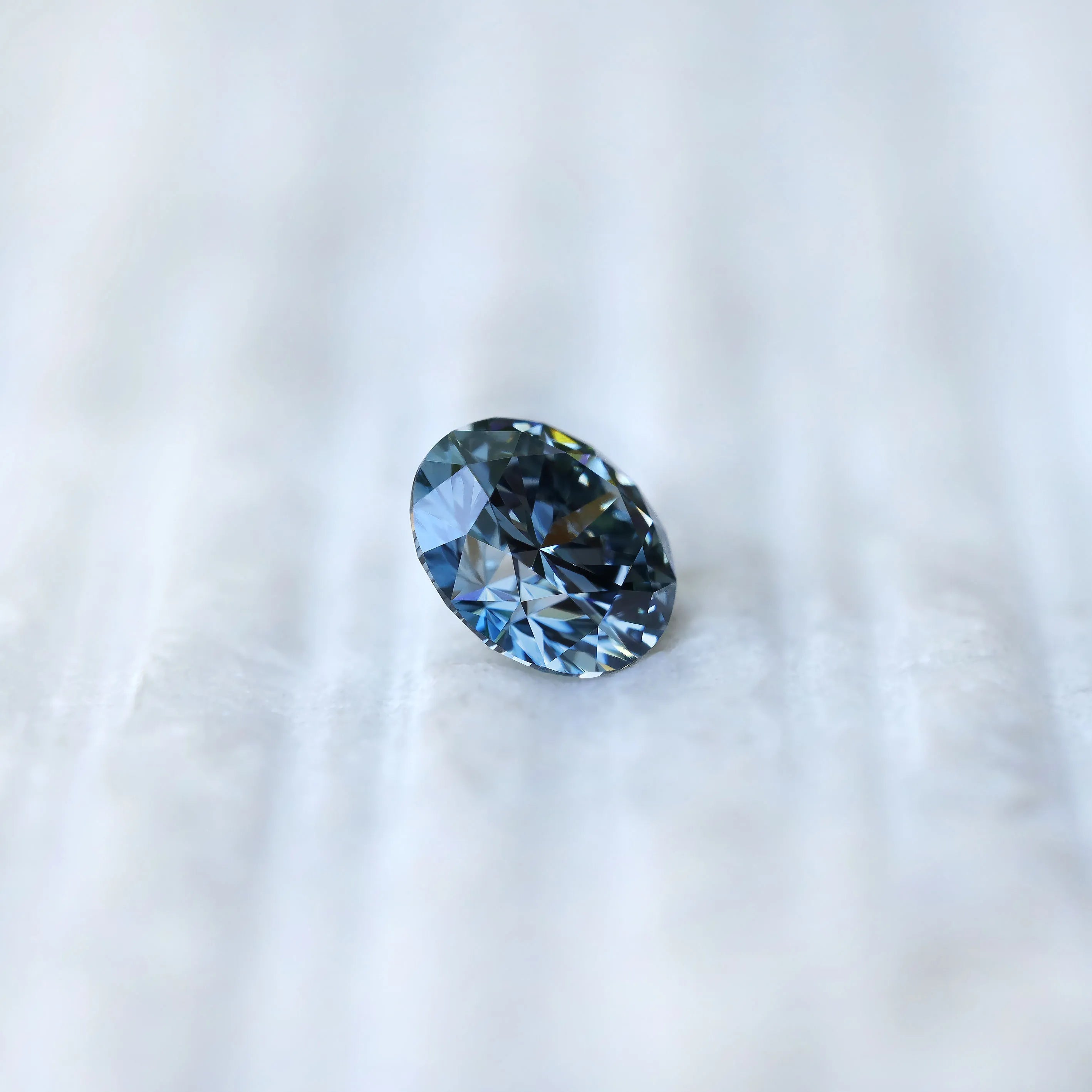 Profile side view of round intense blue loose diamond
