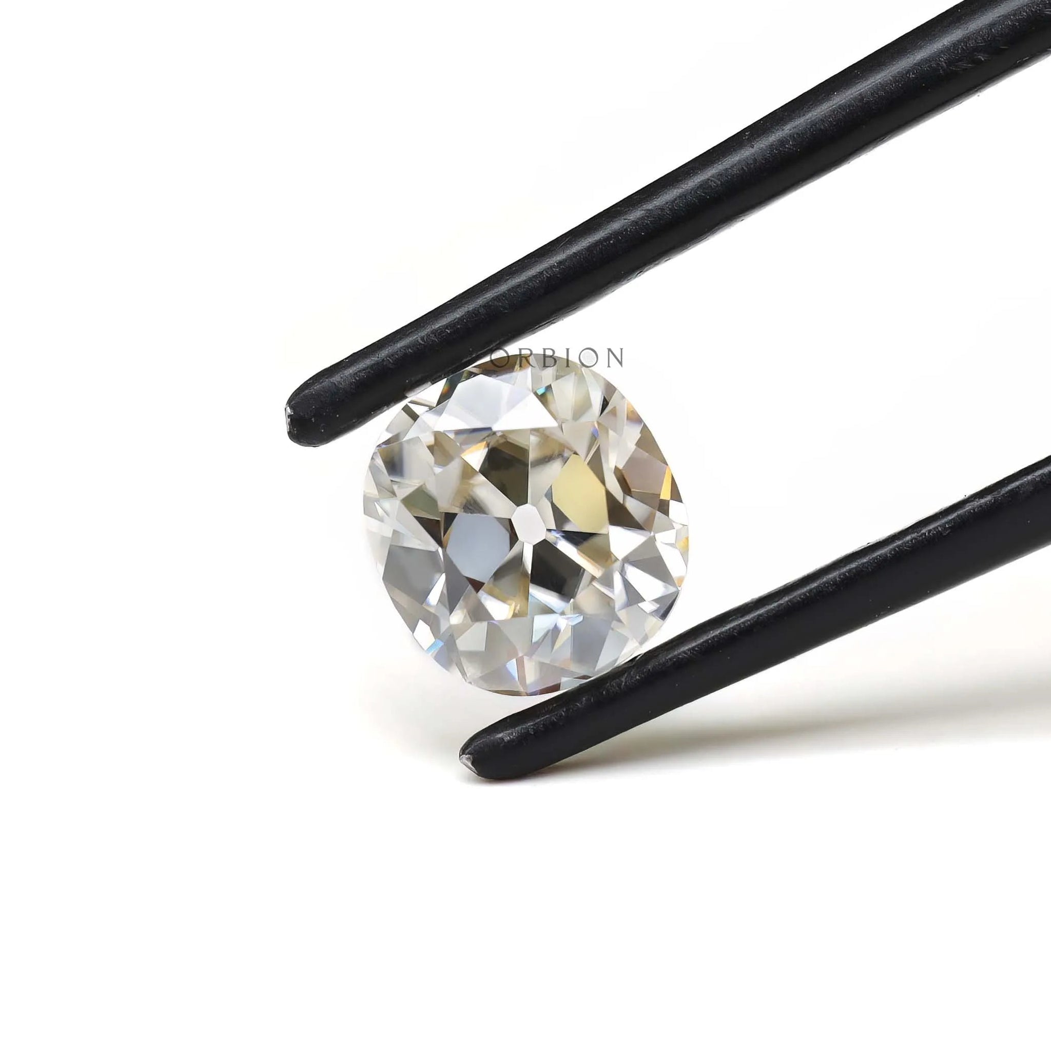 Old mine cut elongated cushion moissanite shown in tweezers