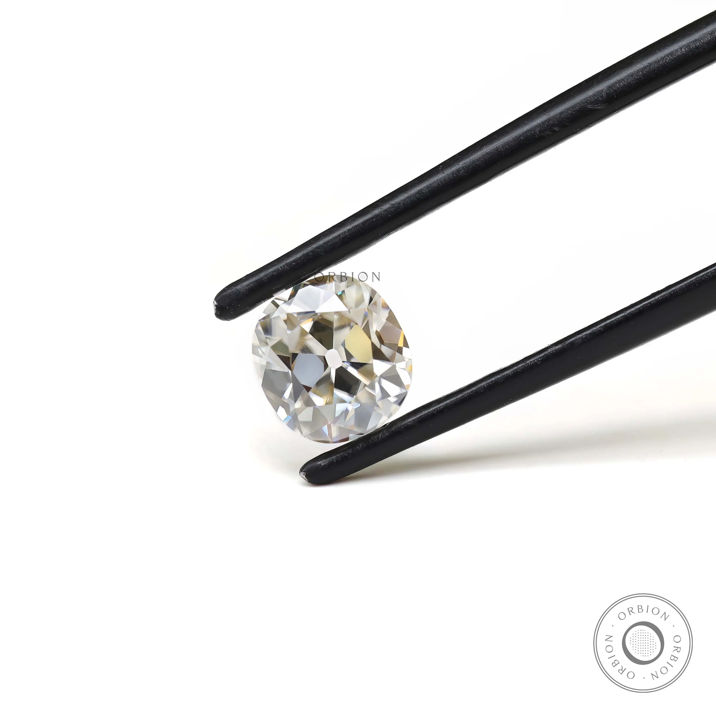 Old mine cut elongated cushion moissanite shown in tweezers