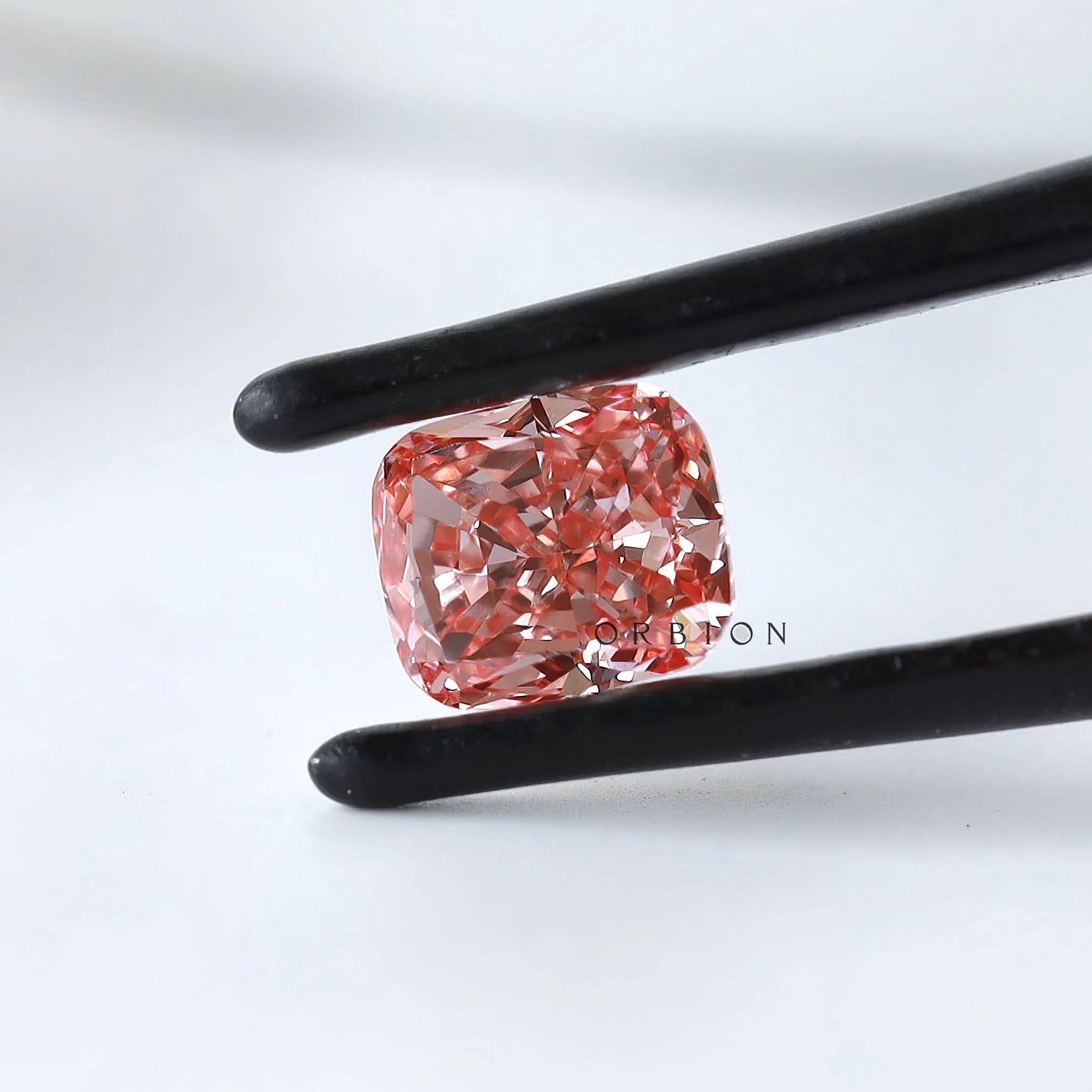 Side angled view of pink cushion modified lab diamond