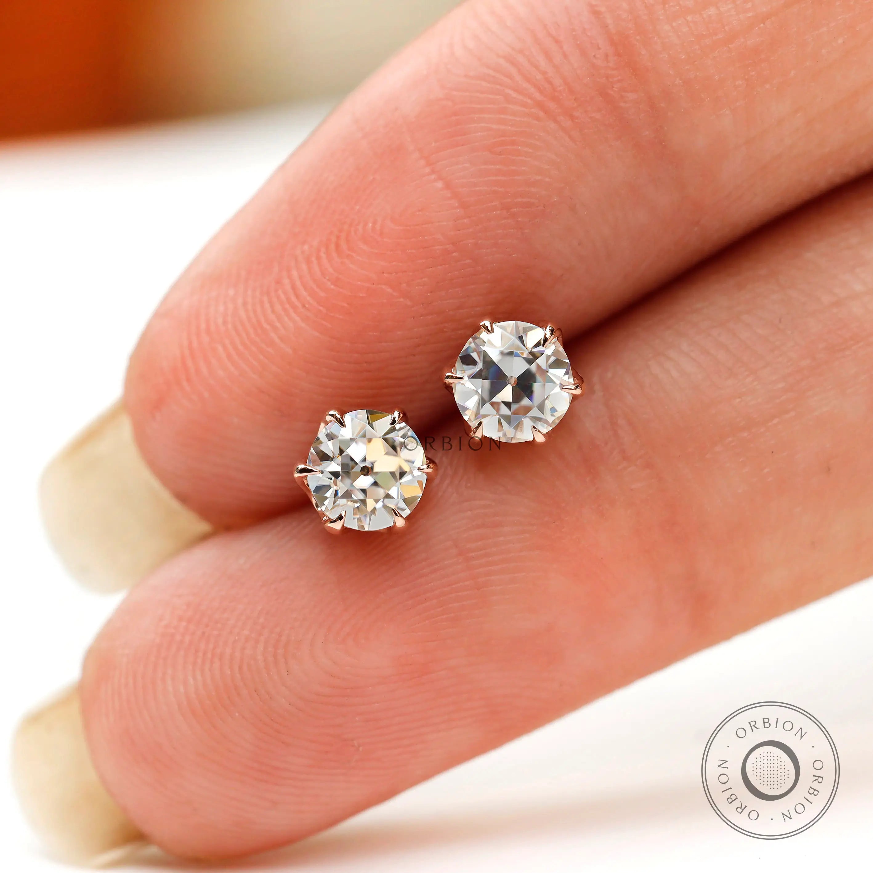 Finger scale view round moissanite rose gold studs