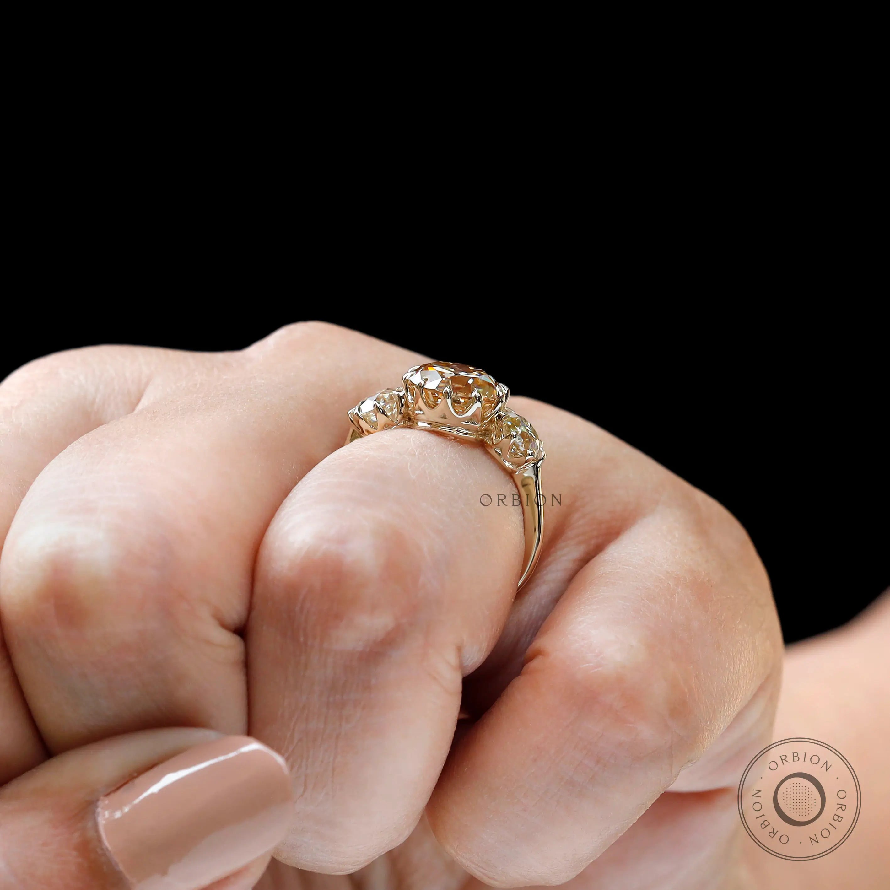 Side wear champagne moissanite three stone ring on finger