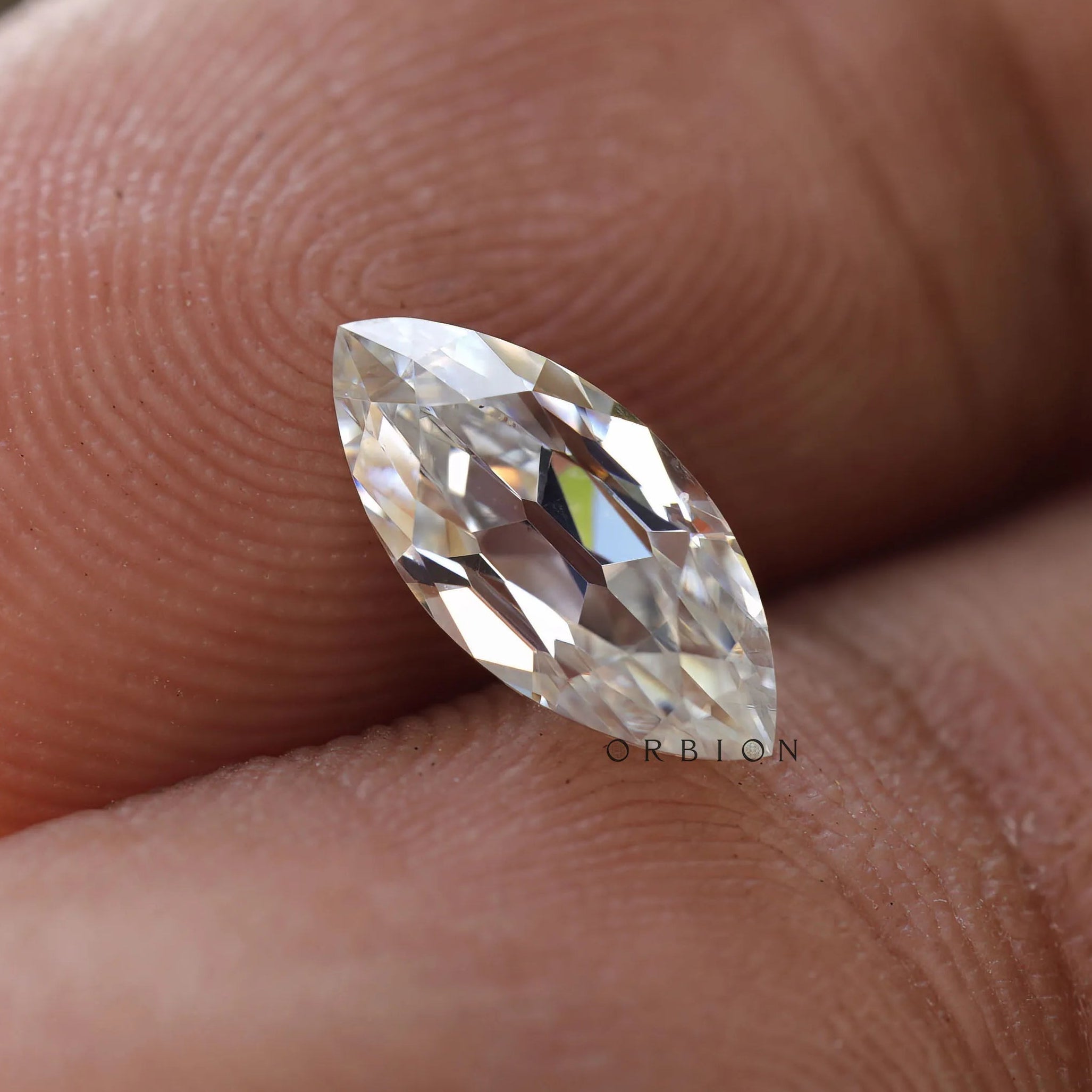 Moissanite marquise stone on a hand for scale