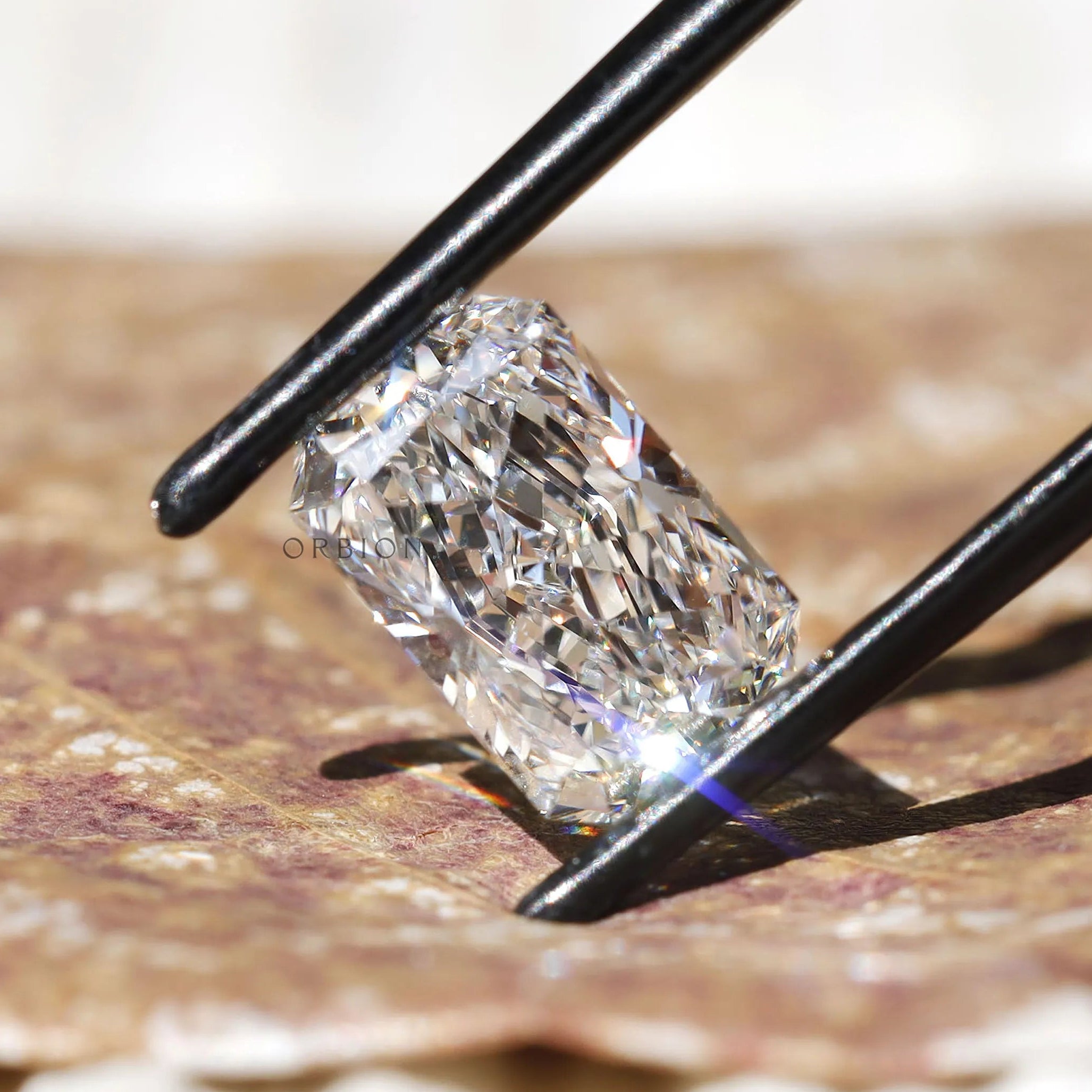 Radiant cut lab diamond shown on fingertip close-up