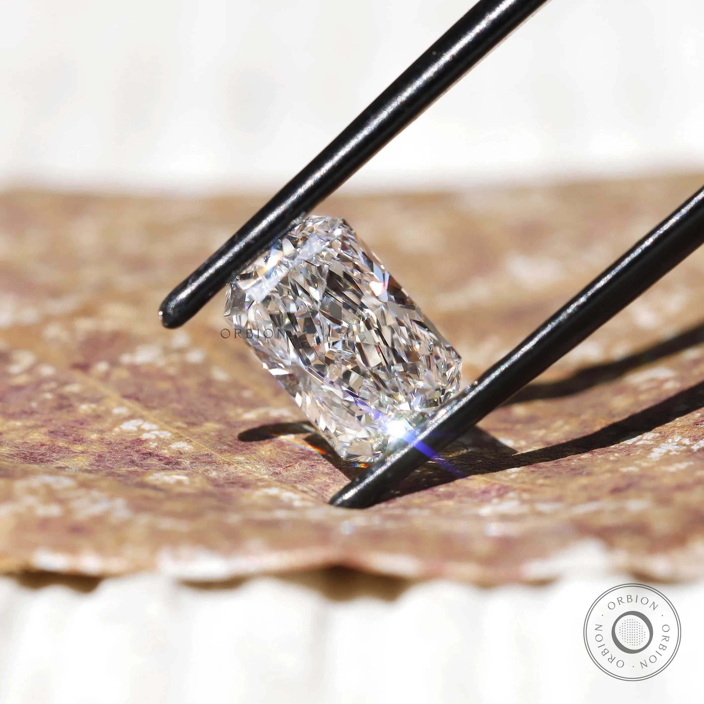 Radiant cut lab diamond shown on fingertip close-up