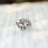 Cushion moissanite side profile on light textured surface