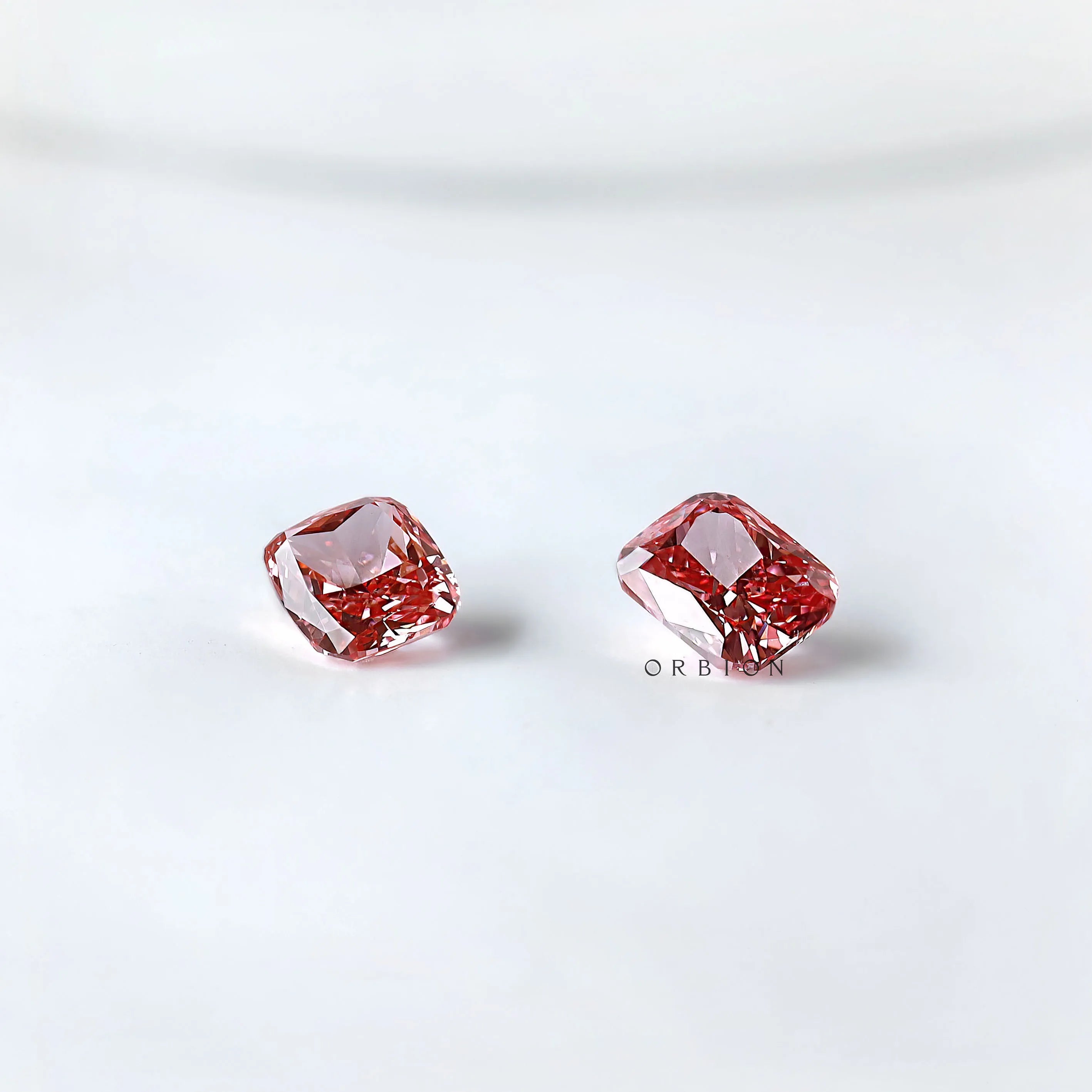 Angled pair view of vivid pink cushion loose diamonds
