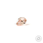 Pear shaped pink lab diamond resting on white background