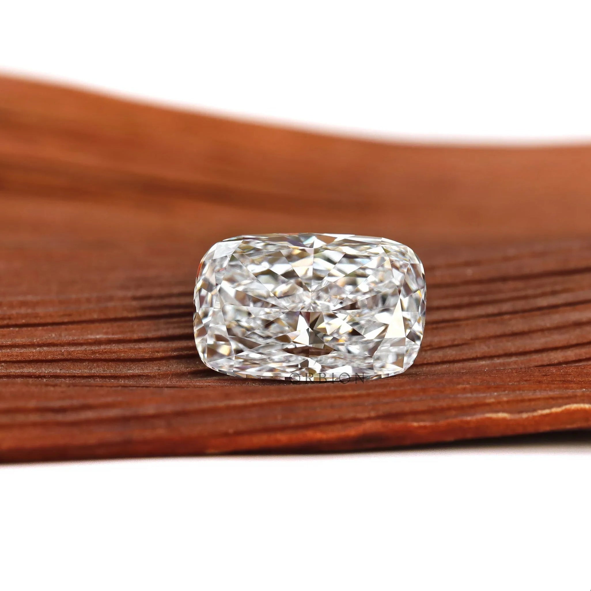 Elongated cushion loose lab diamond resting flat on wooden surface