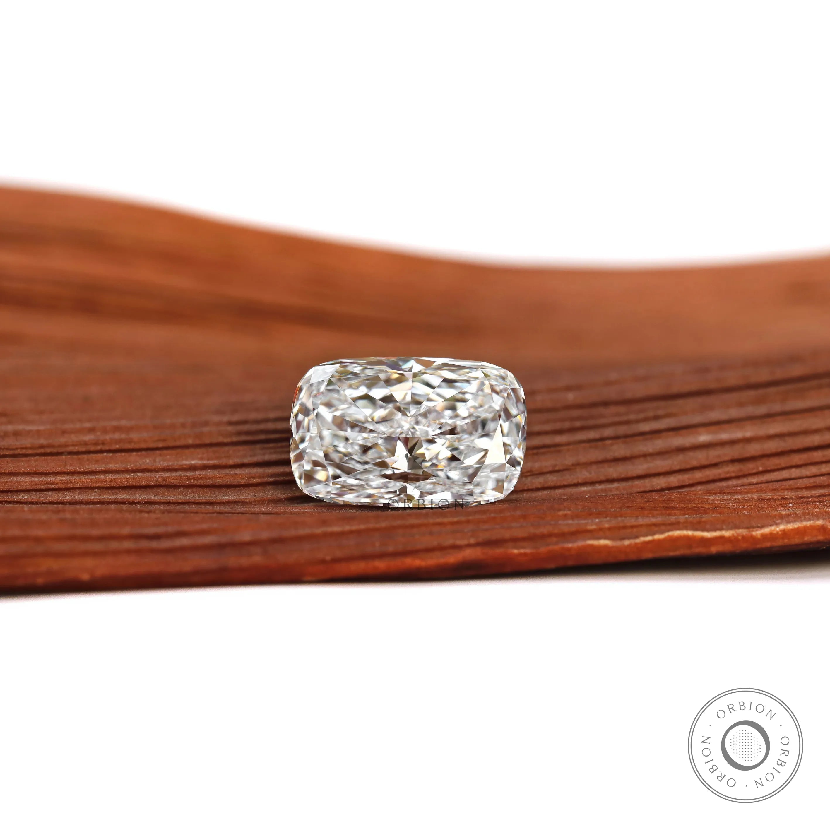 Elongated cushion loose lab diamond resting flat on wooden surface