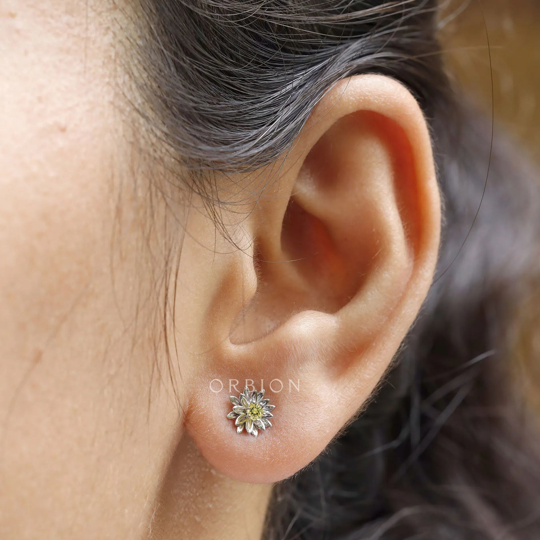 Model wearing lotus flower stud earrings with yellow lab diamond
