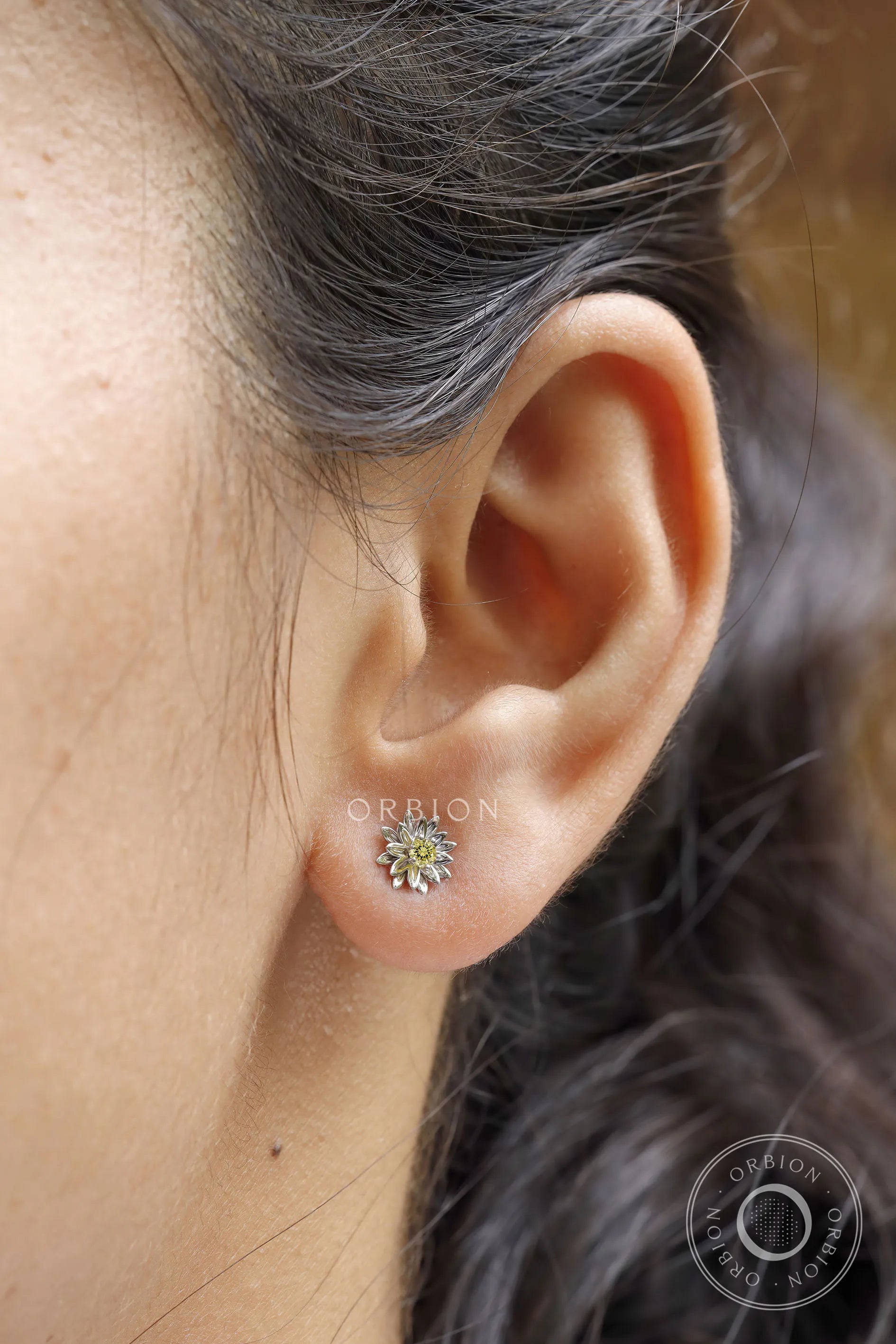Model wearing lotus flower stud earrings with yellow lab diamond