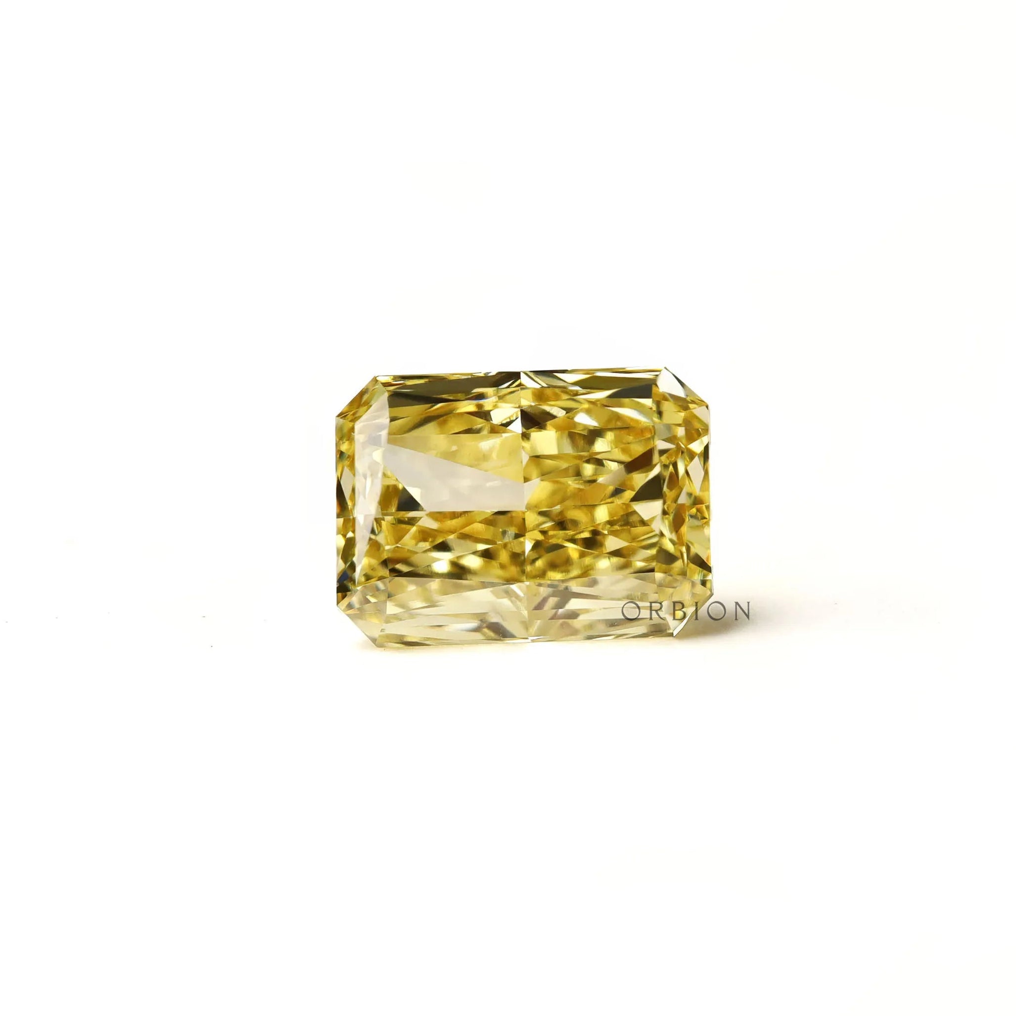 Fancy intense yellow radiant diamond resting flat white background