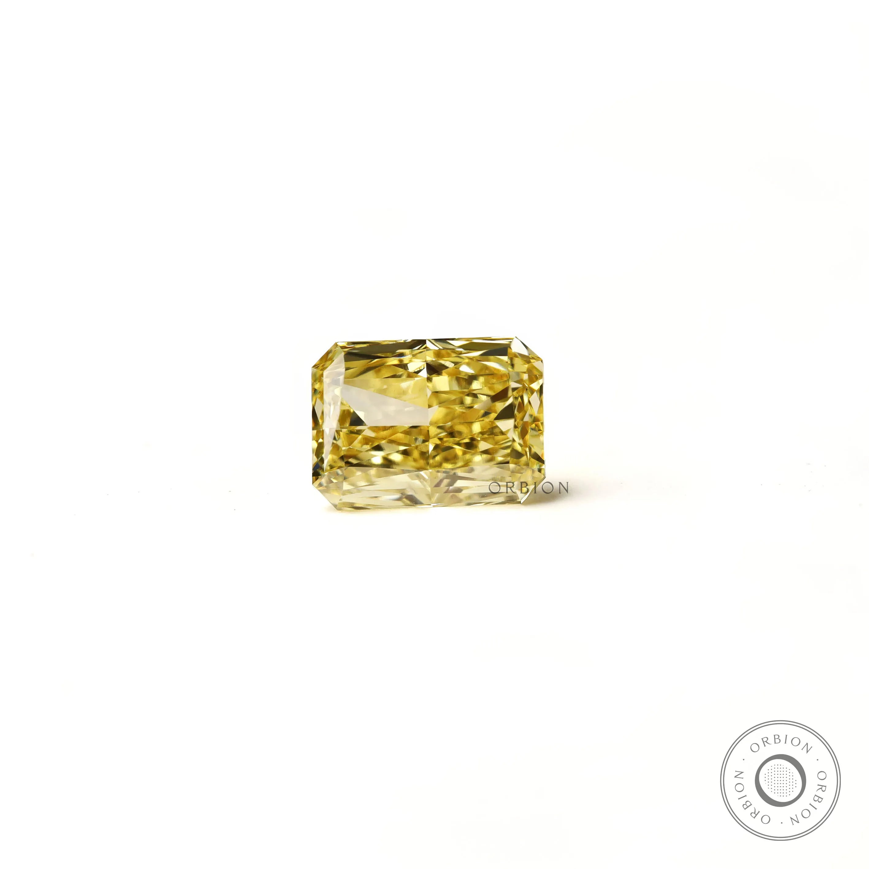 Fancy intense yellow radiant diamond resting flat white background