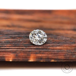 Face-up round loose lab diamond on wooden background
