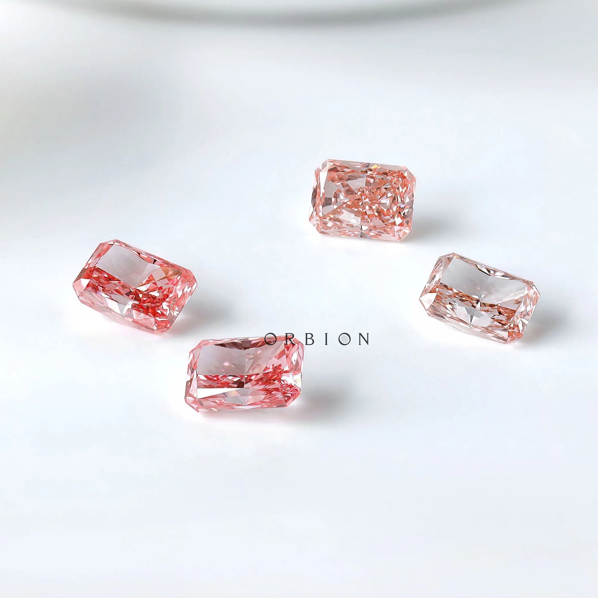 Four pink radiant lab diamonds showing color variation