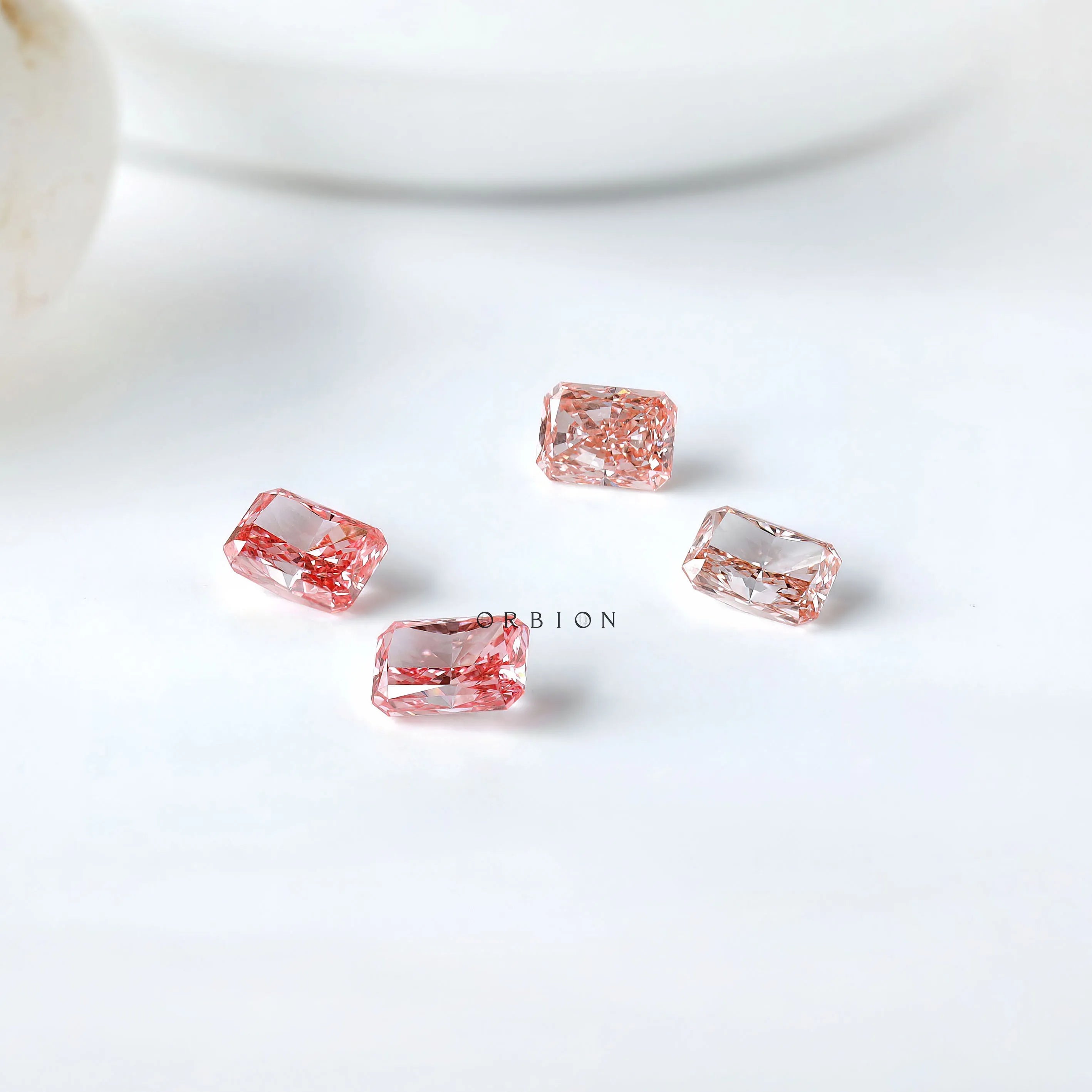 Four pink radiant lab diamonds showing color variation