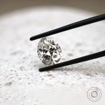 Close view of DEF pear lab diamond held between black tweezers 
