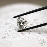Close view of DEF pear lab diamond held between black tweezers 