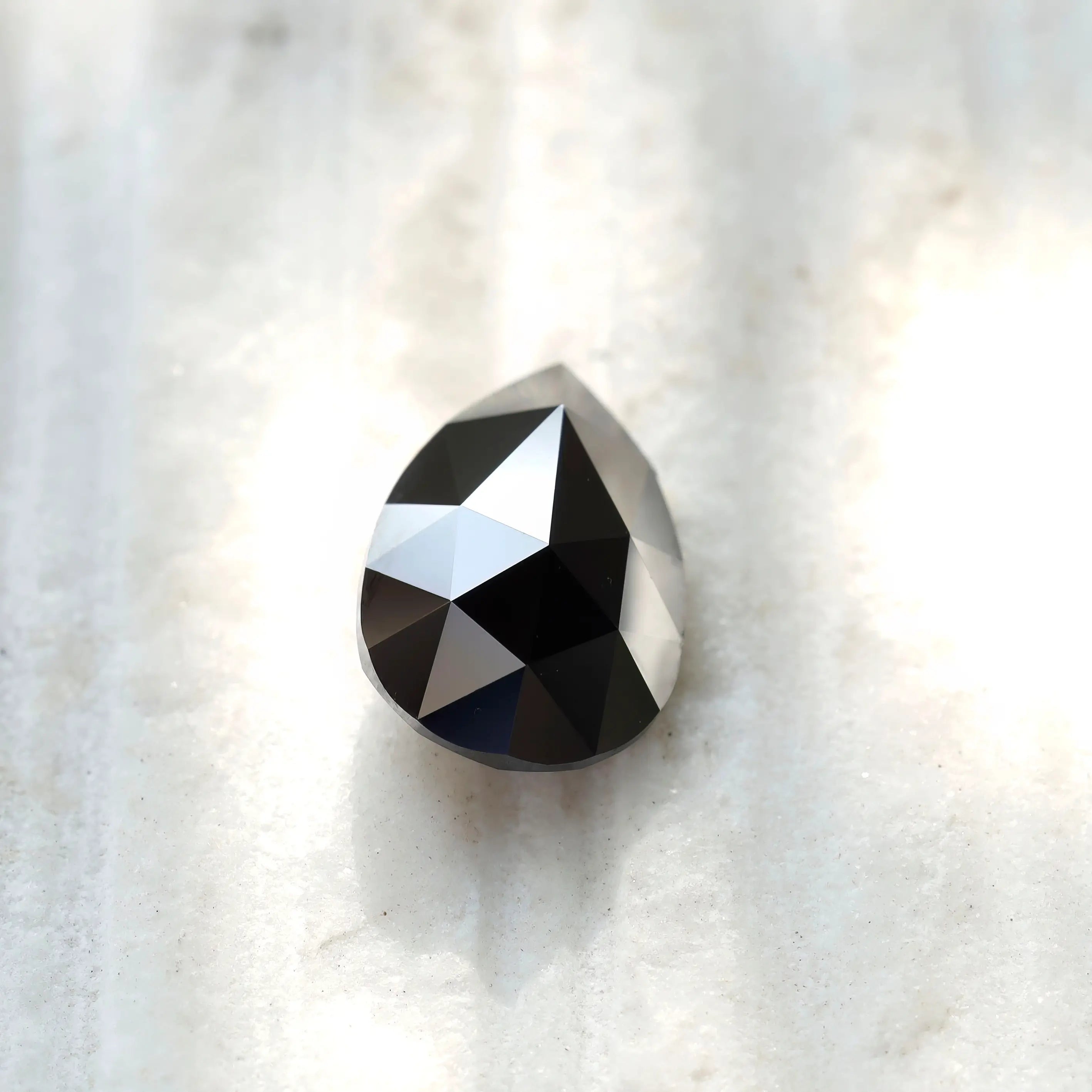 Two black pear moissanite stones with soft background