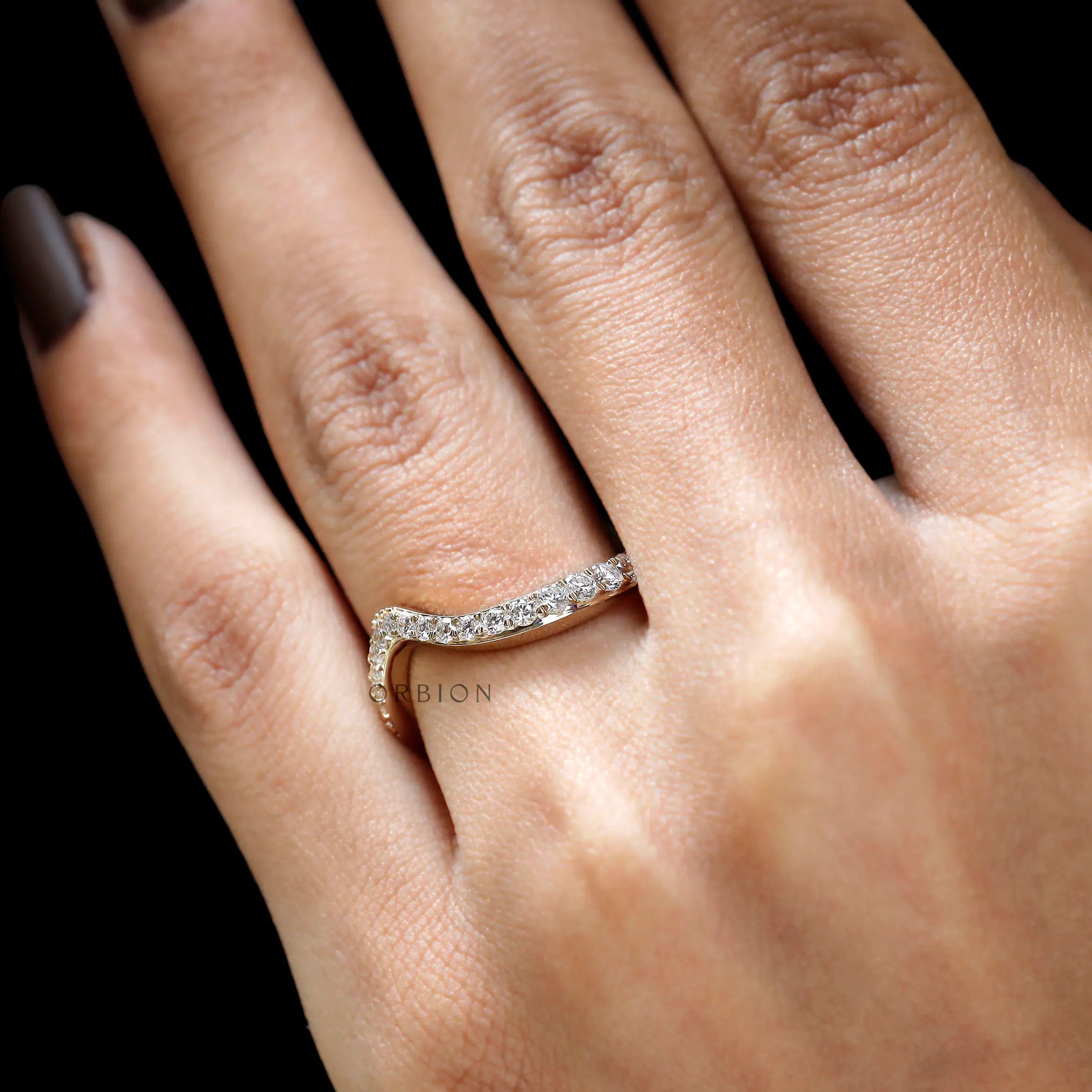 Close-up of wave diamond band on finger