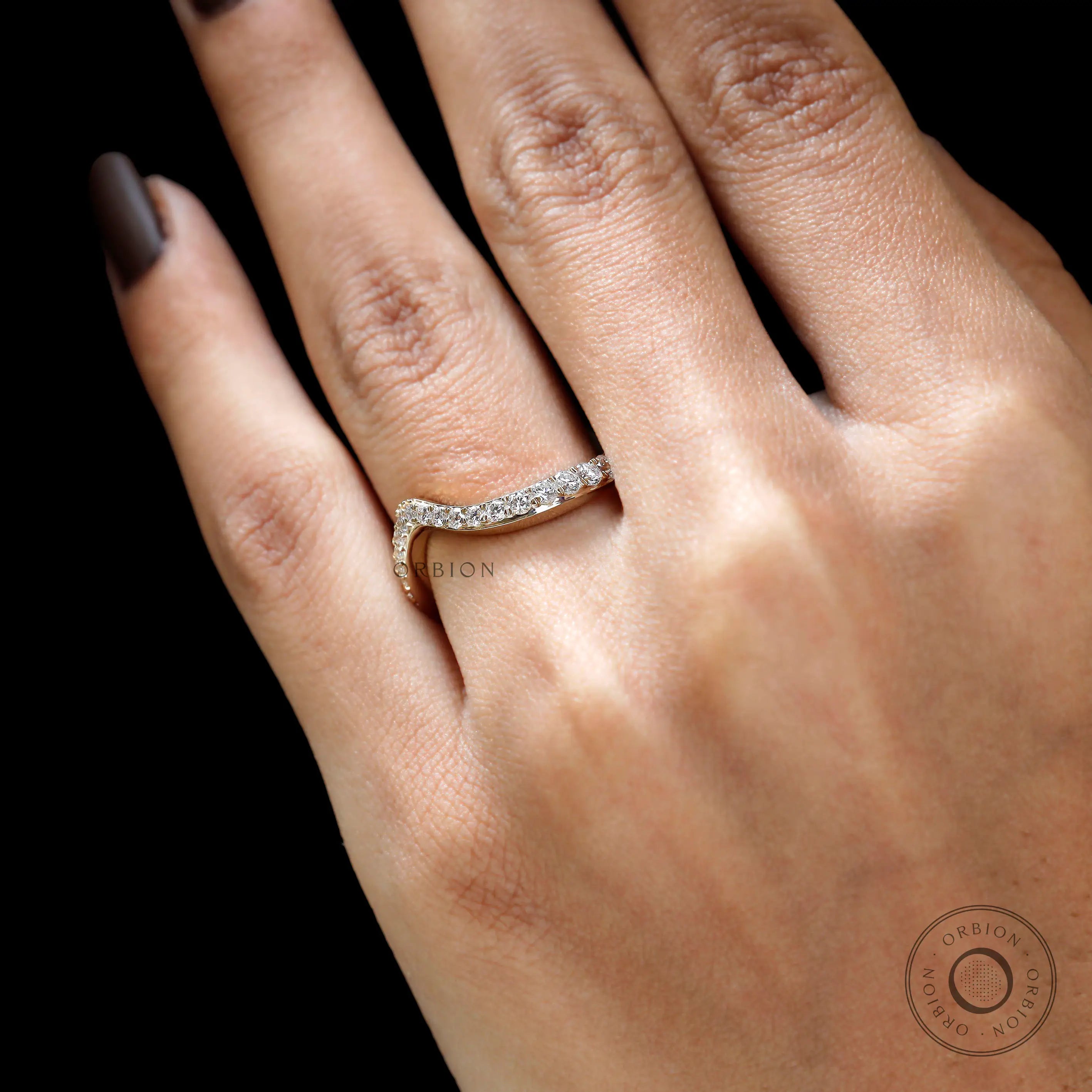 Close-up of wave diamond band on finger
