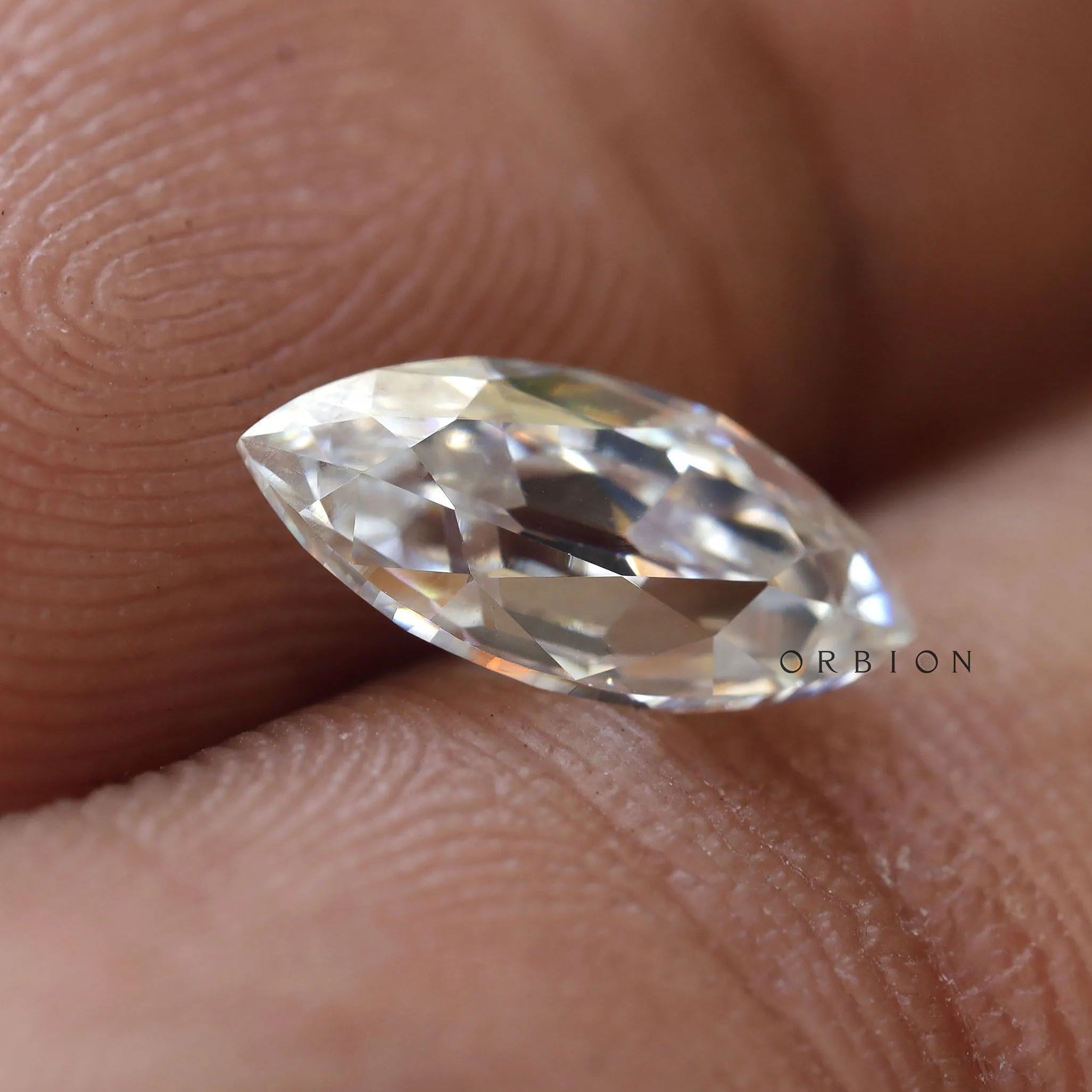 Elegant marquise moissanite stone held between fingers