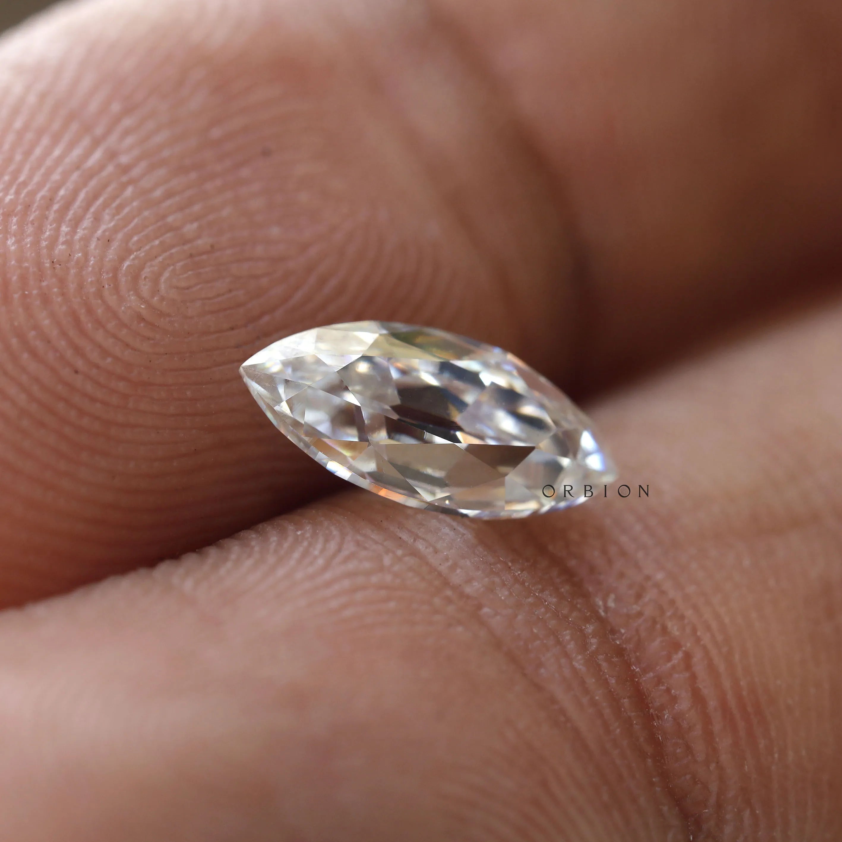 Elegant marquise moissanite stone held between fingers
