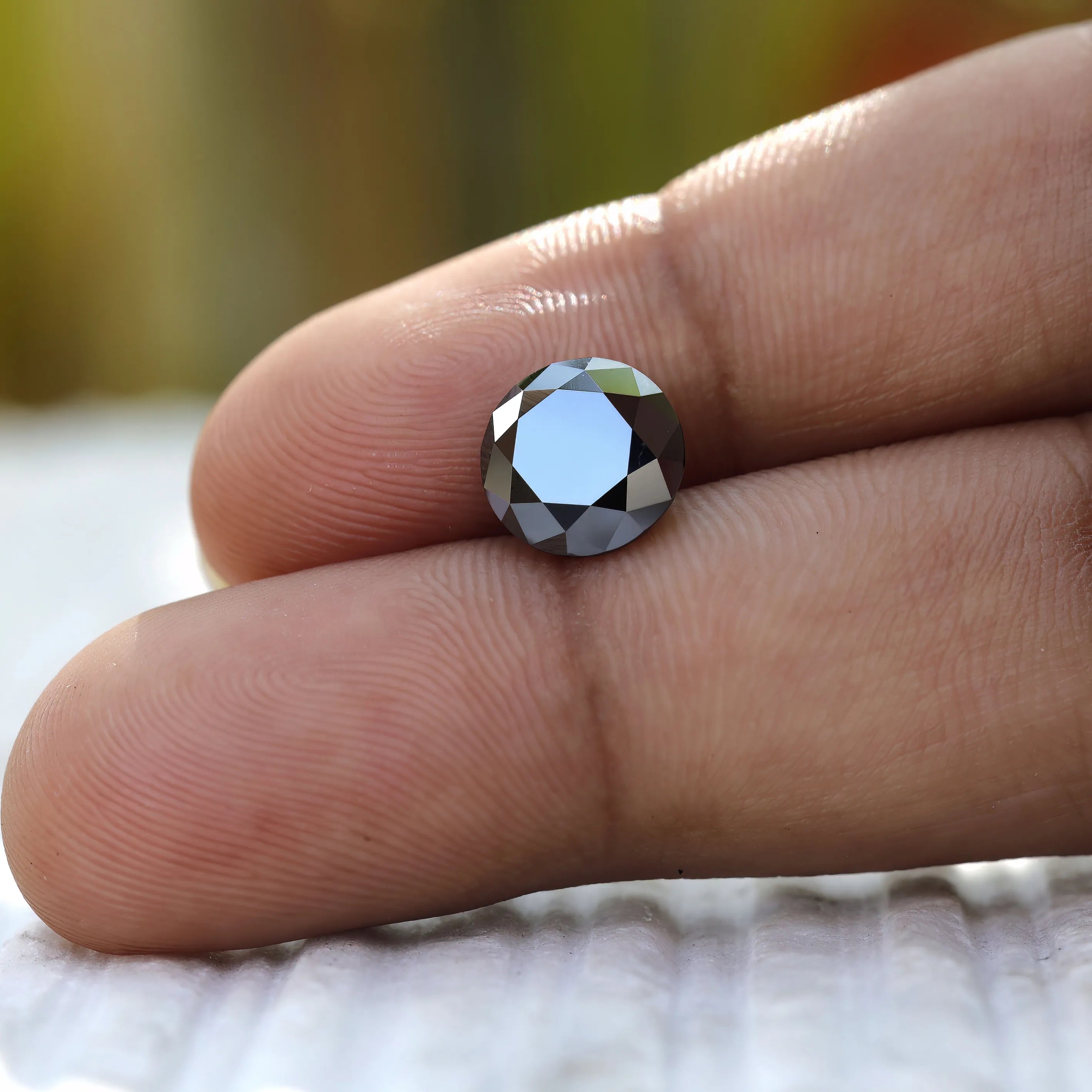 Sparkling 2 CT Round Black Moissanite stone on hand