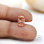 Close fingertip view of fancy pink radiant lab diamond