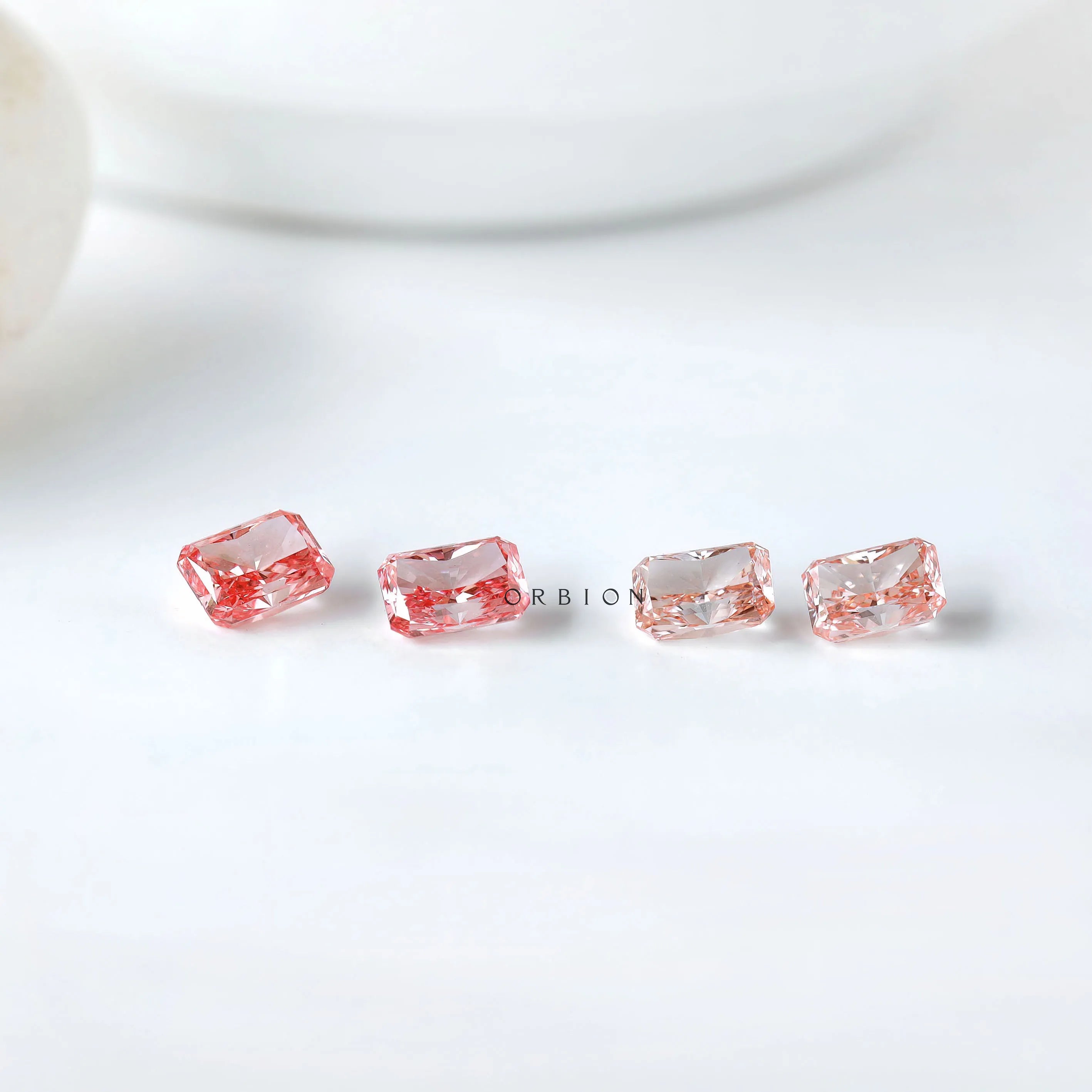 Row display of four radiant pink loose diamonds