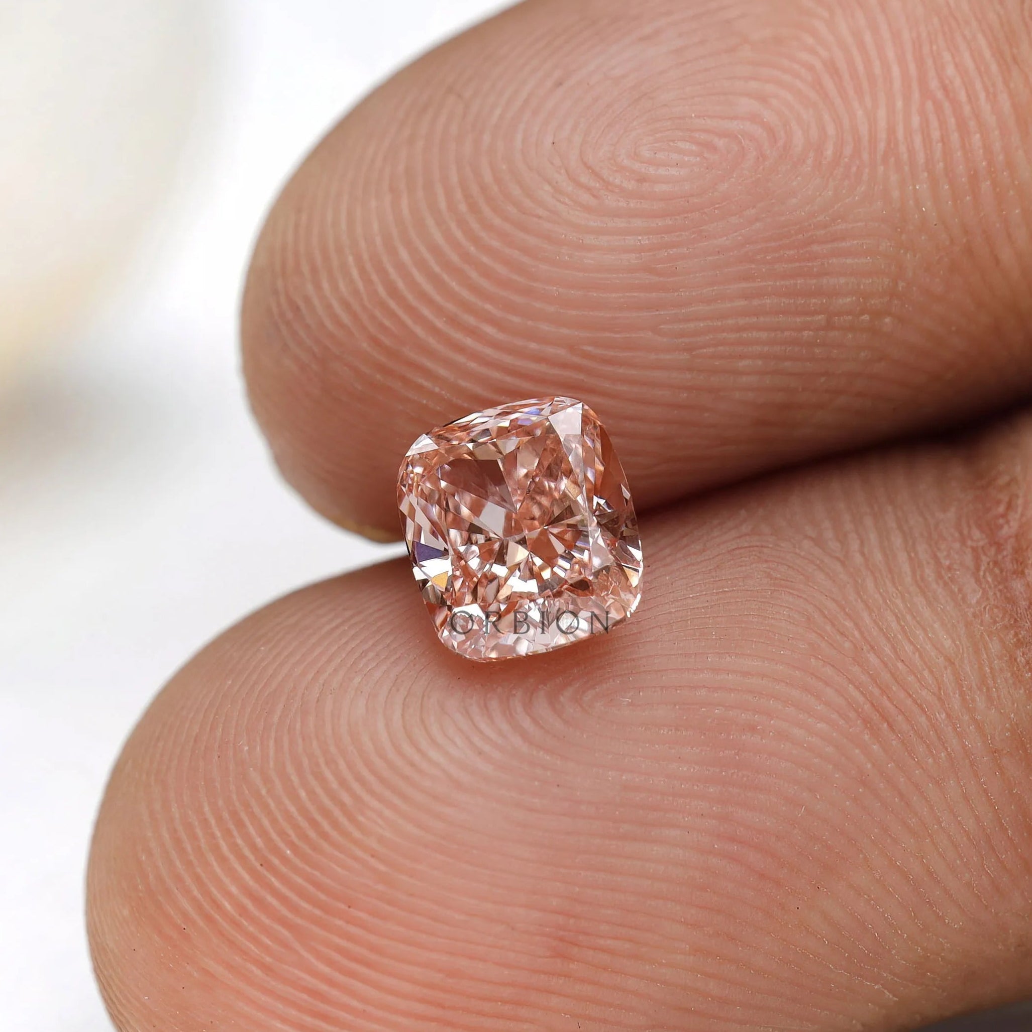 Fancy pink elongated cushion loose diamond on fingertip display