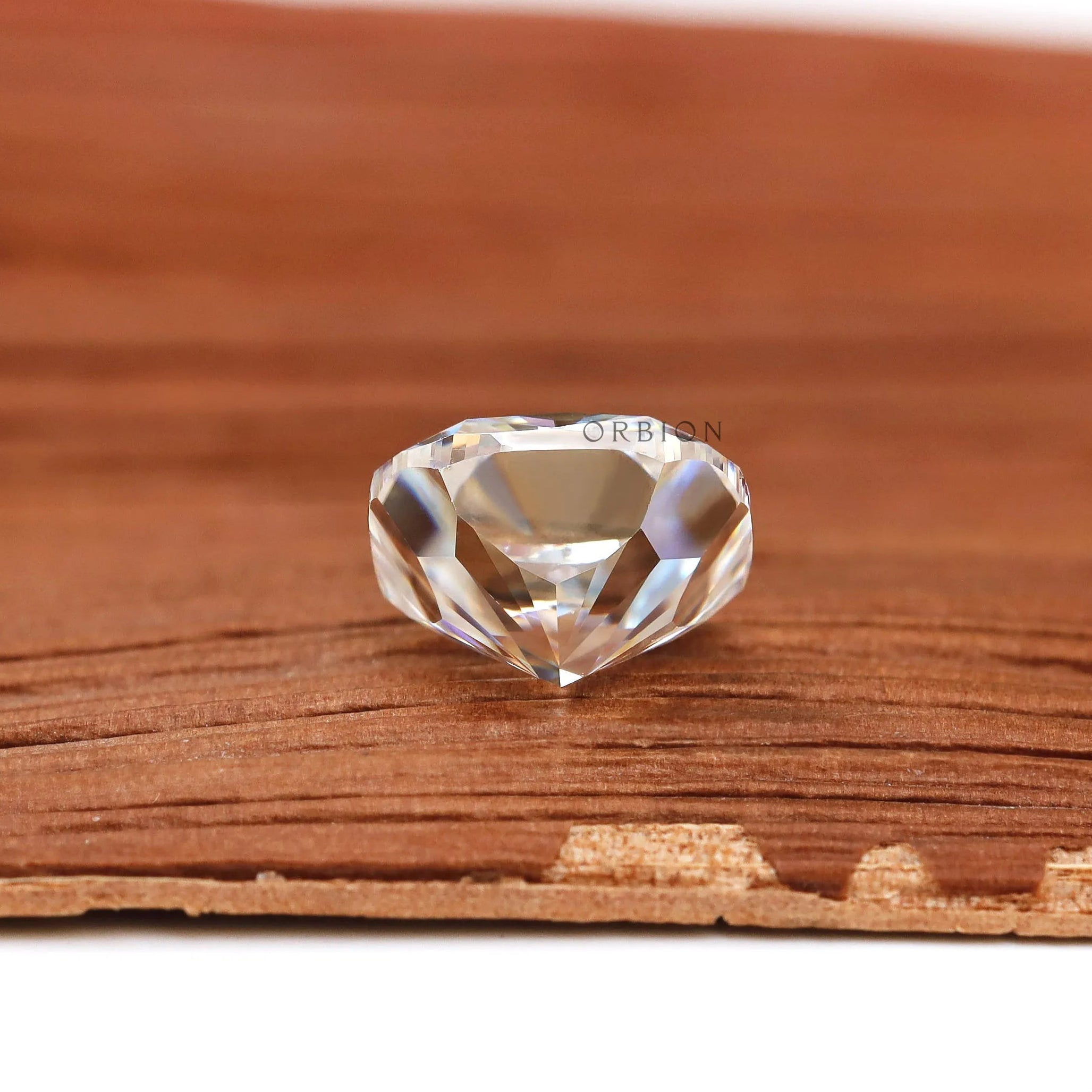 Bottom profile cushion brilliant cut loose moissanite on wood