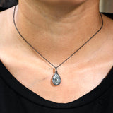 Pear moissanite pendant necklace styled on neckline close view