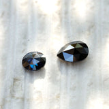 Detailed view of black pear moissanite stone in hand