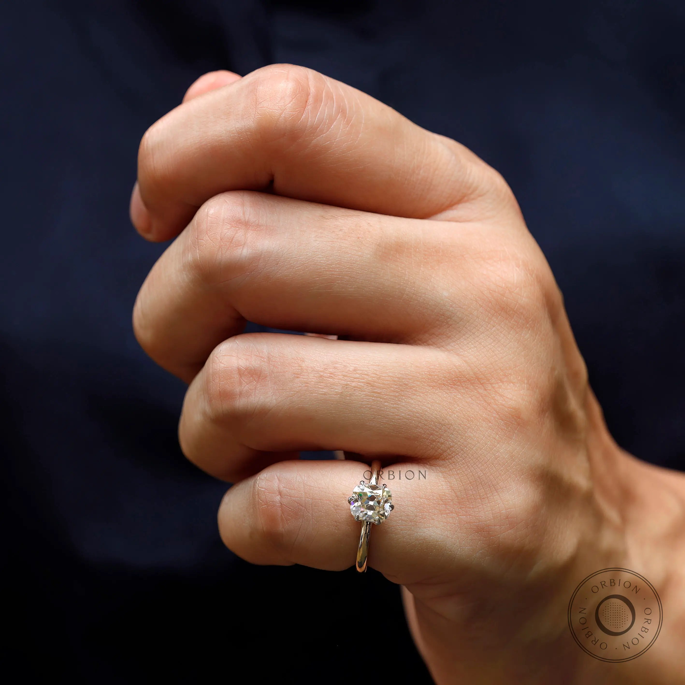 Front wear view of elongated cushion moissanite ring on hand