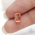 Vertical fingertip view of radiant cut fancy pink diamond