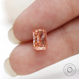 Vertical fingertip view of radiant cut fancy pink diamond