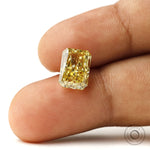 Fancy intense yellow radiant lab diamond shown on fingertip