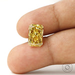 Fancy vivid yellow radiant lab diamond shown on fingertip