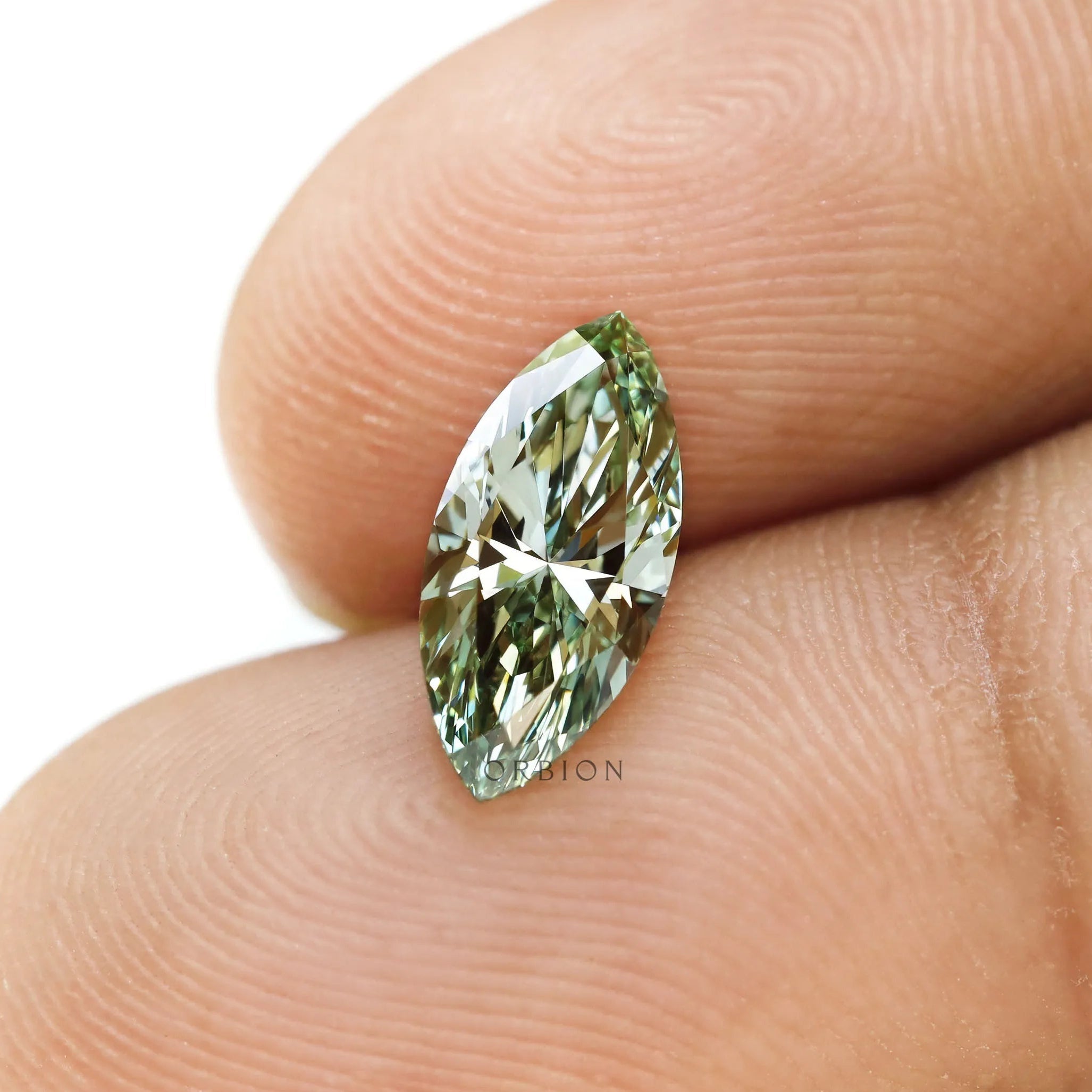 Fancy vivid green marquise lab diamond shown on fingertip