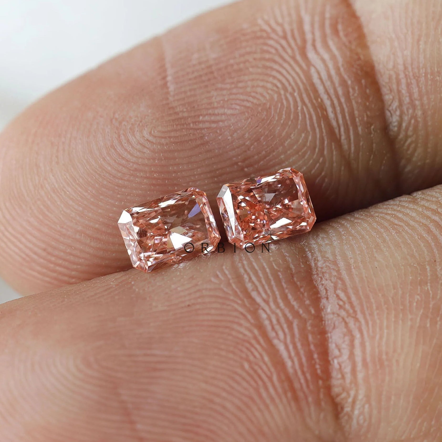 Macro fingertip view of matching pink radiant pair