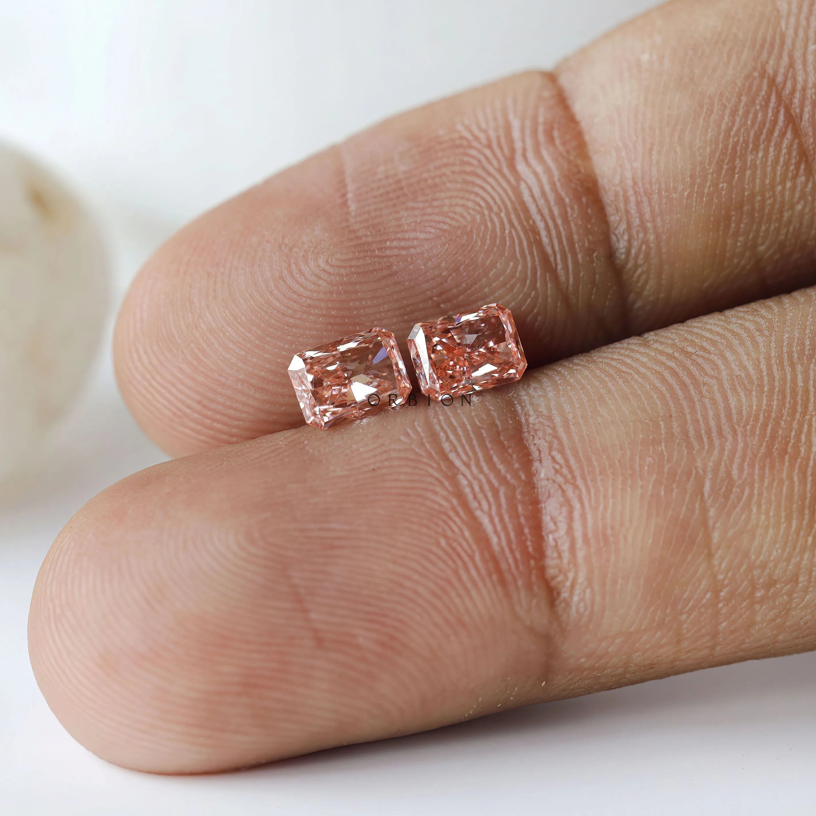 Macro fingertip view of matching pink radiant pair