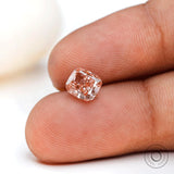 Close fingertip view of fancy pink elongated cushion diamond
