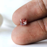 Fancy deep purplish pink cushion diamond shown on fingertip