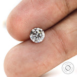 Macro fingertip view of round brilliant loose lab diamond