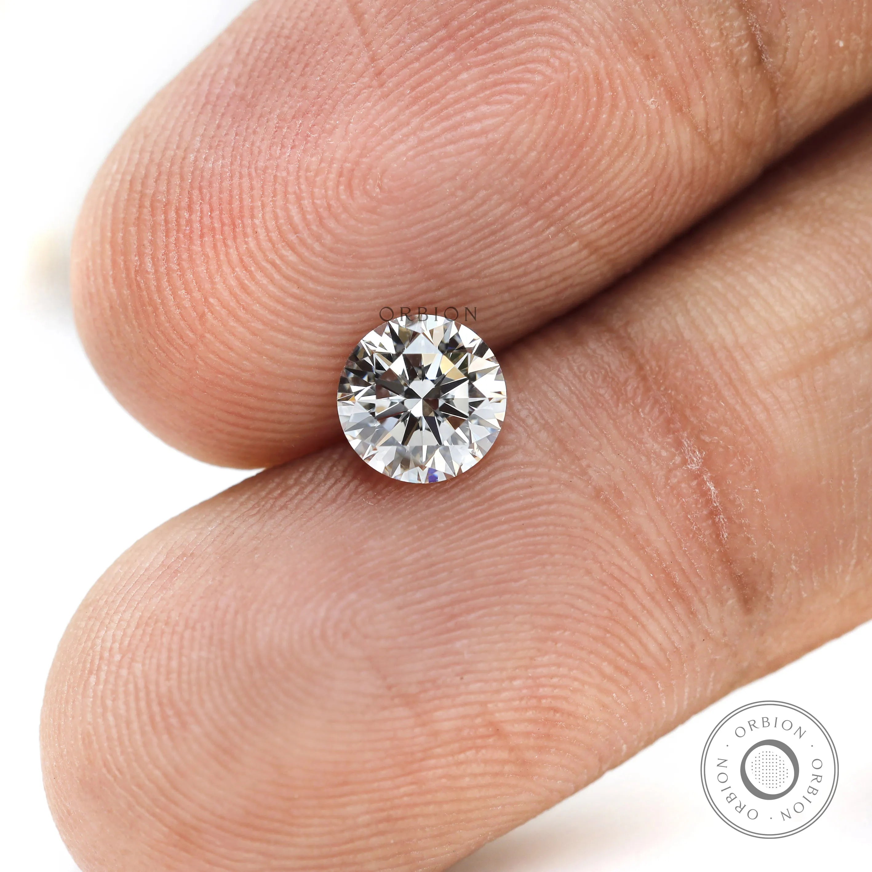 Macro fingertip view of round brilliant loose lab diamond