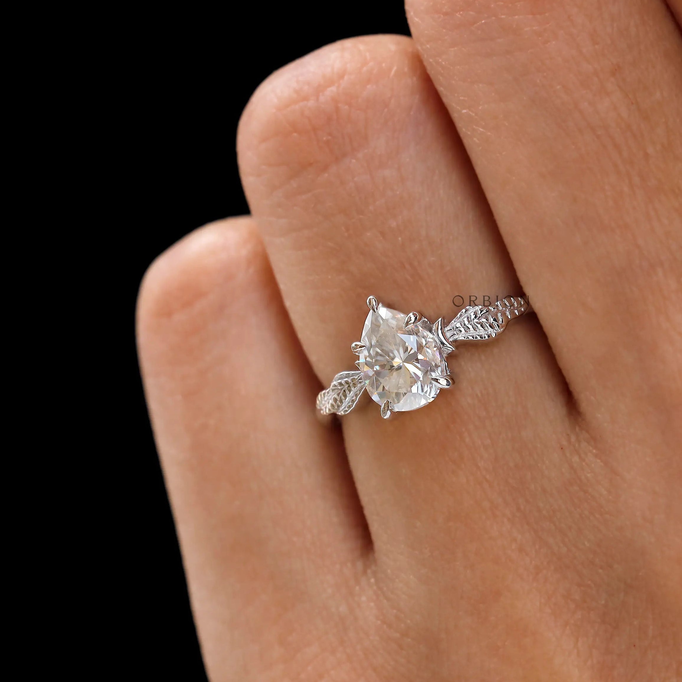 Moissanite engagement ring with leaf engravings on white gold band